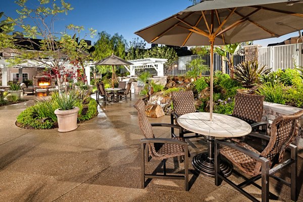 Grill area on a patio at Channel Point Apartments with outdoor seating for social gatherings Perfect for enjoying a sunny day with friends