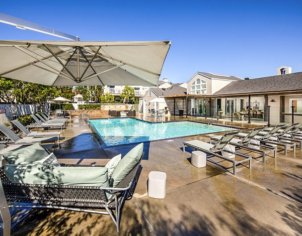 Inviting outdoor pool with spacious deck at Channel Point Apartments offering luxury living in a serene environment