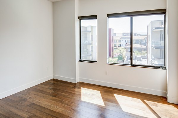Cozy bedroom with modern decor at The Dudley Apartments, offering luxury living in a vibrant community