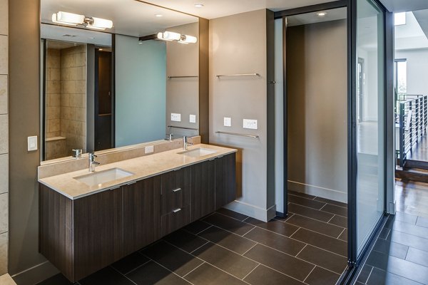 Stylish bathroom with marble countertops and modern fixtures at The Dudley Apartments