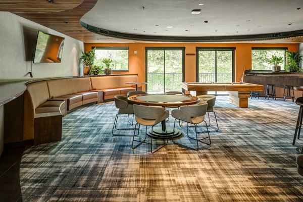 Clubhouse game room featuring billiards and lounge seating at The Dudley Apartments, Greystar luxury community