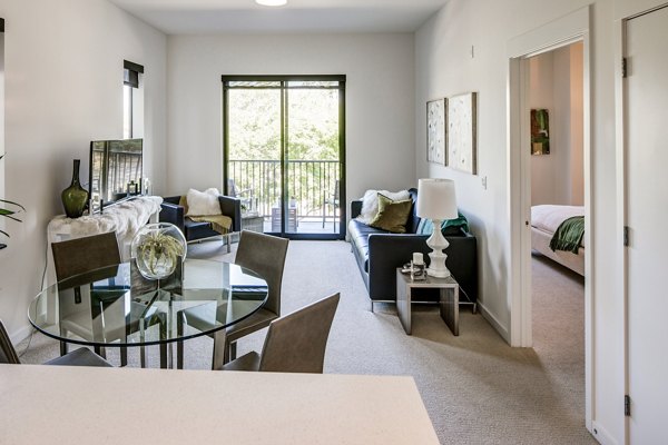 Dining room with modern decor at The Dudley Apartments featuring elegant dining set and contemporary lighting