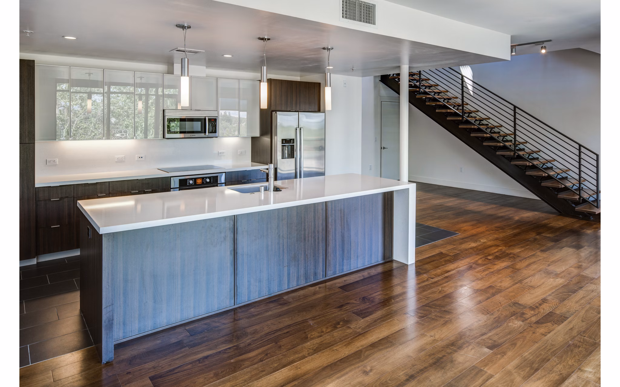 Modern kitchen boasting granite countertops and stainless steel appliances at The Dudley Apartments