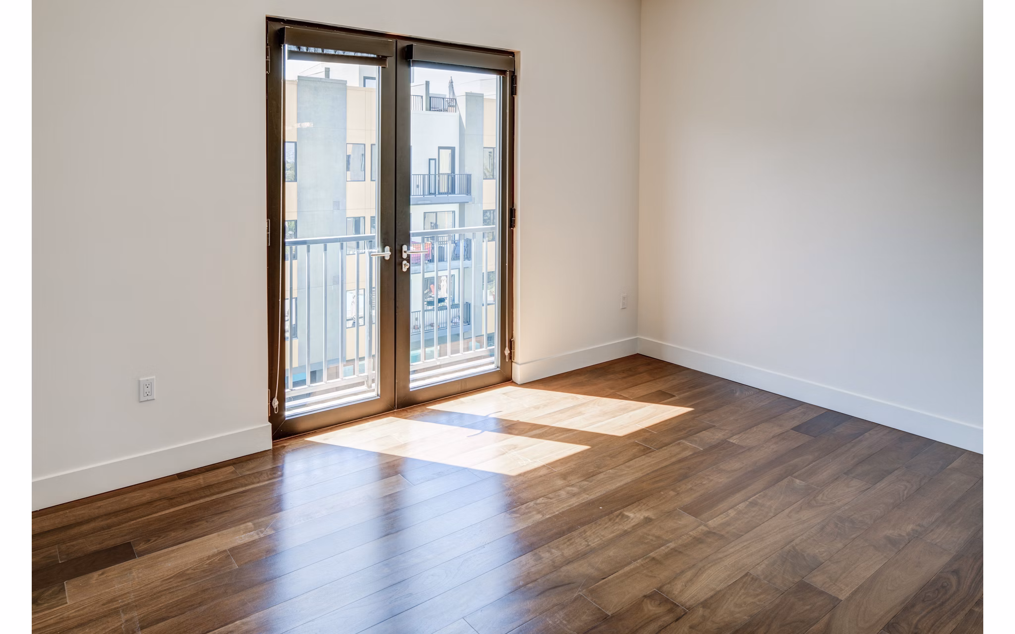 Spacious living room with modern decor and large windows at The Dudley Apartments, luxury community by Greystar