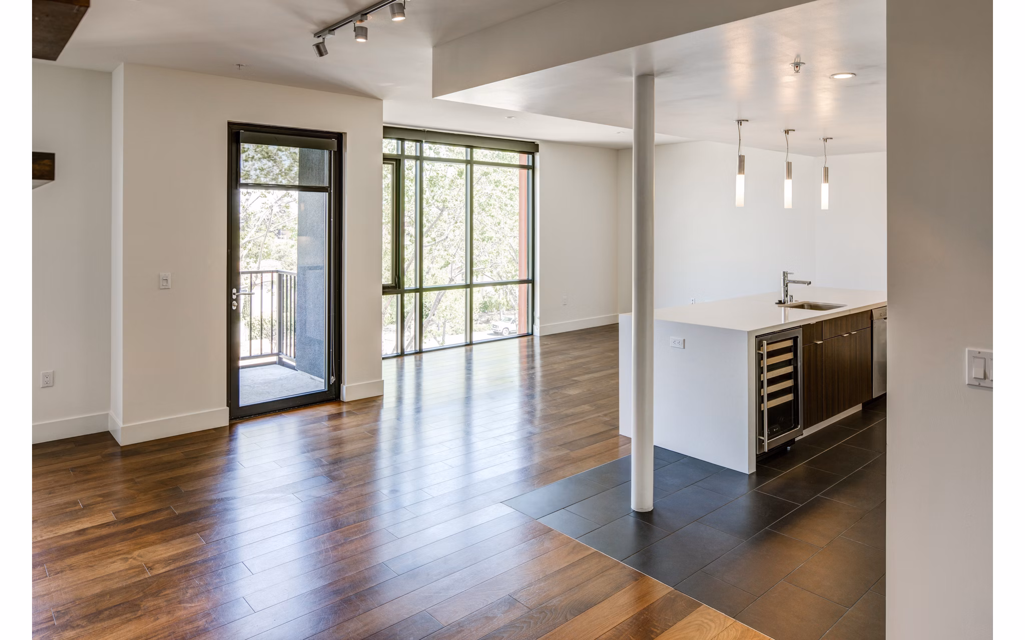 Living room with modern furnishings and a large window at The Dudley Apartments, luxury apartments by Greystar in a prime location