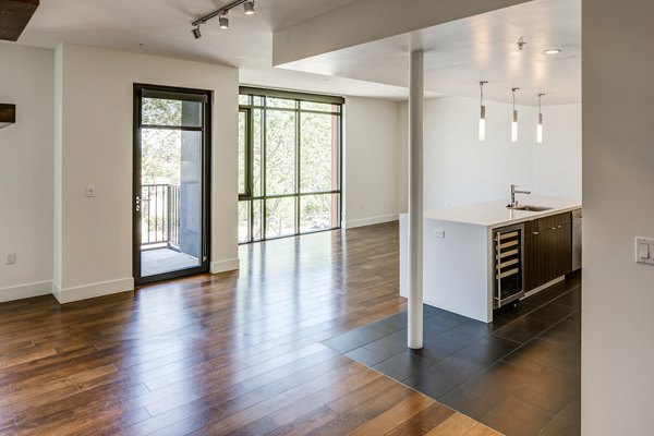 Living room with modern furnishings and a large window at The Dudley Apartments, luxury apartments by Greystar in a prime location