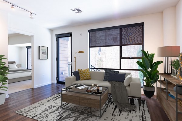 Living room with modern furnishings and natural light at The Dudley Apartments