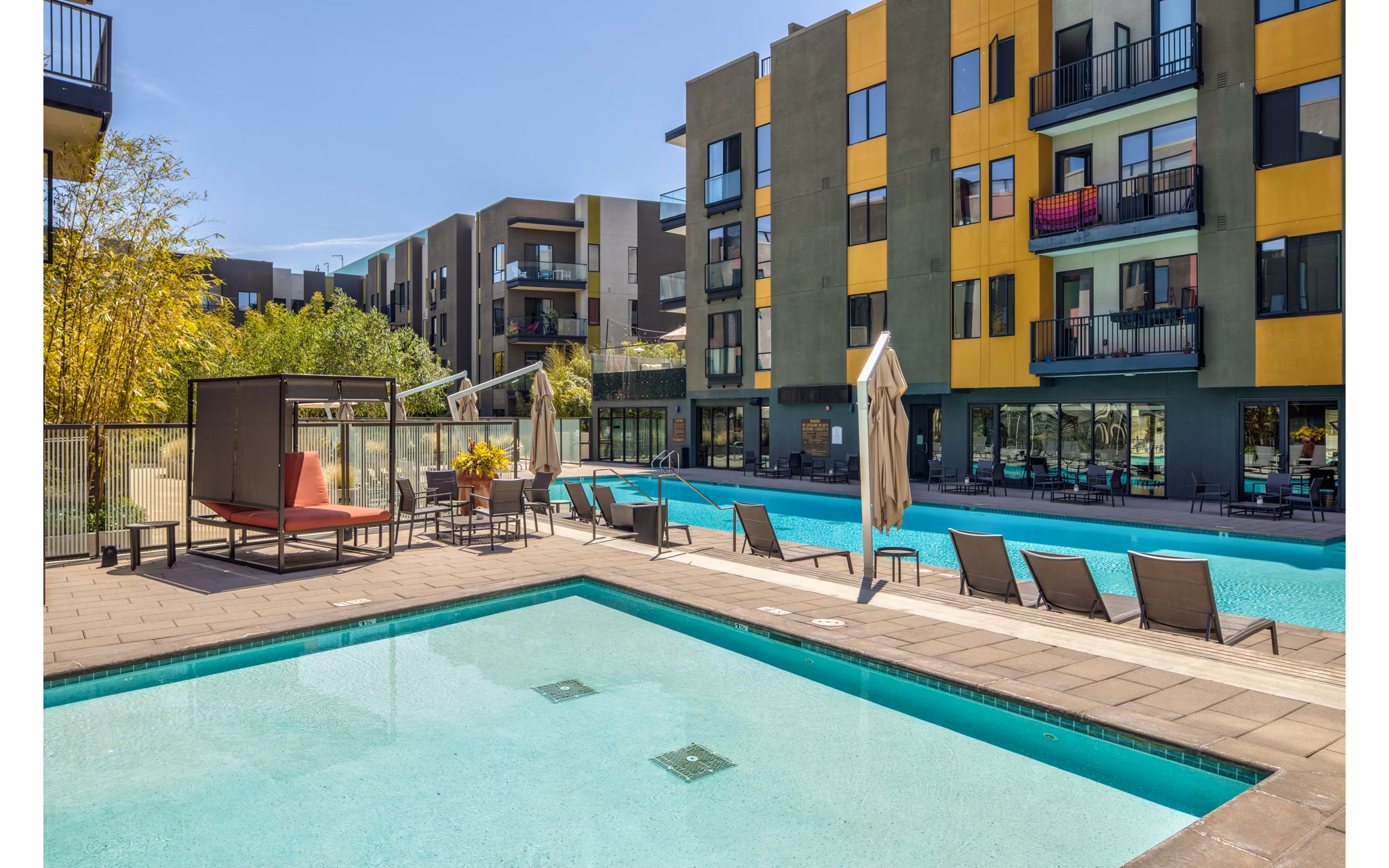 Luxurious outdoor pool area at The Dudley Apartments designed for relaxation and recreation, offering a serene oasis for residents