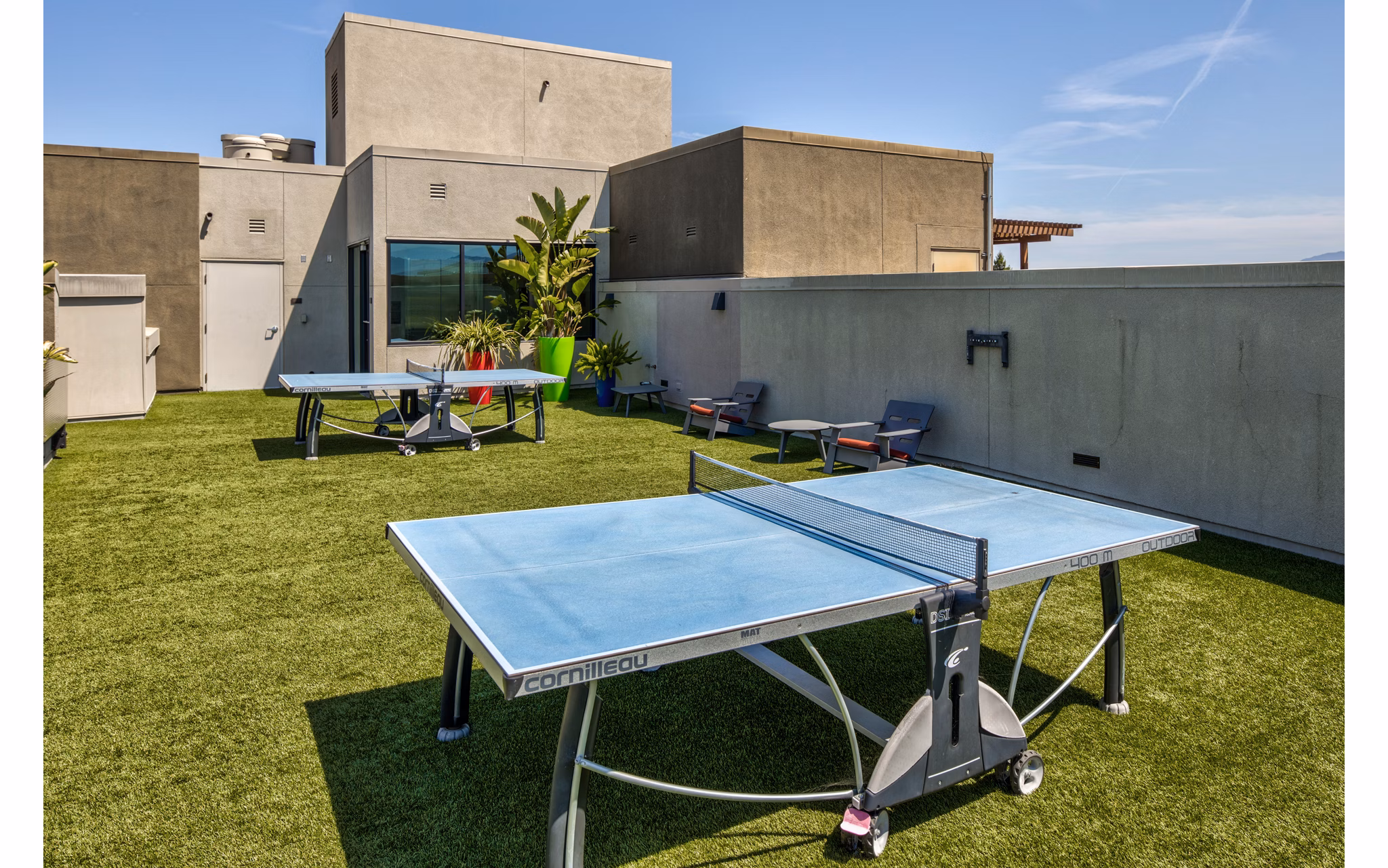 Patio recreational area with modern seating and greenery at The Dudley Apartments