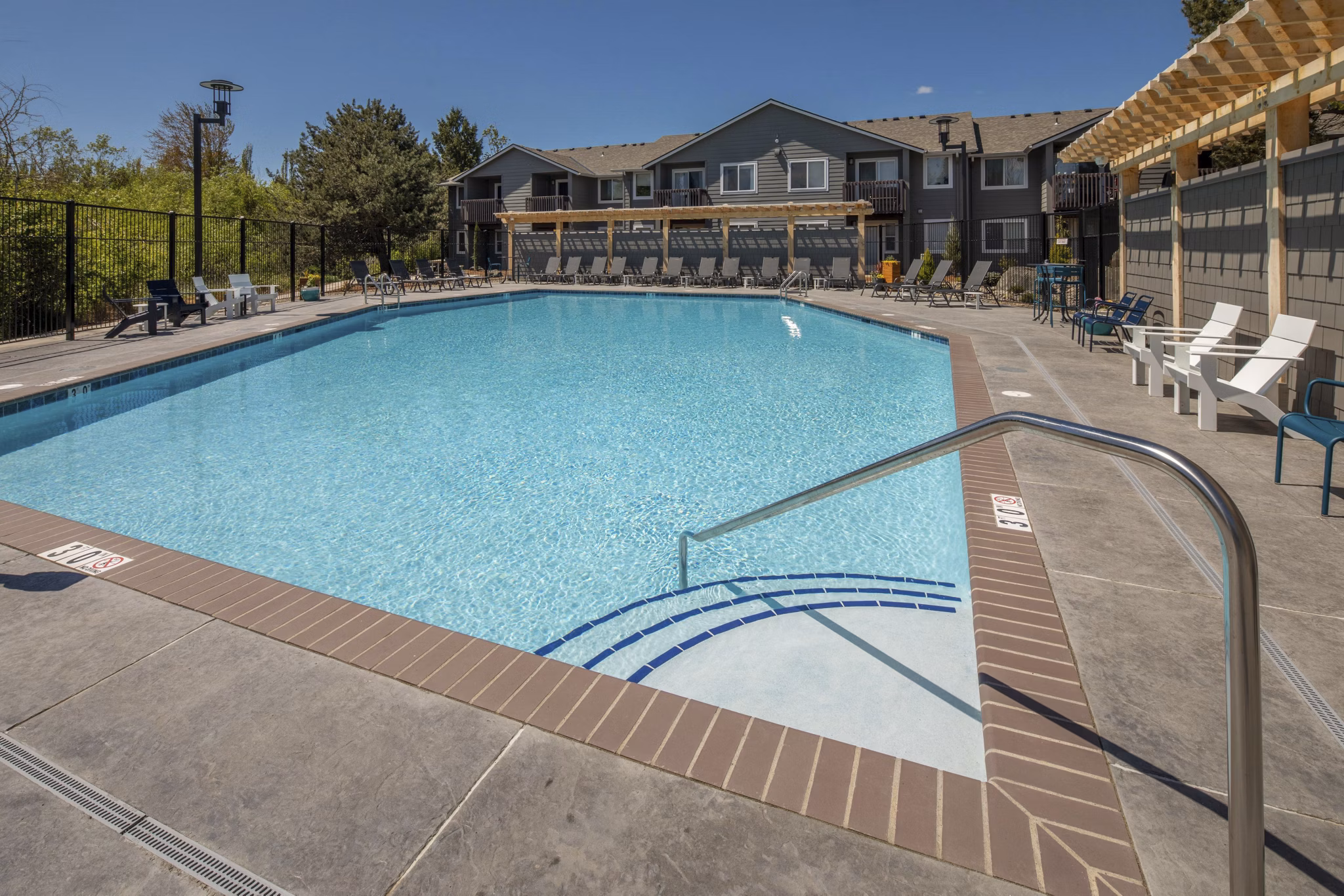 Lap pool adjacent to lush gardens at Creekside Apartments, offering relaxation and recreation in a serene environment