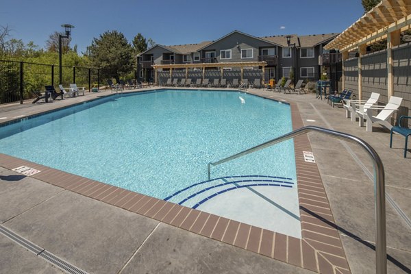 Lap pool adjacent to lush gardens at Creekside Apartments, offering relaxation and recreation in a serene environment