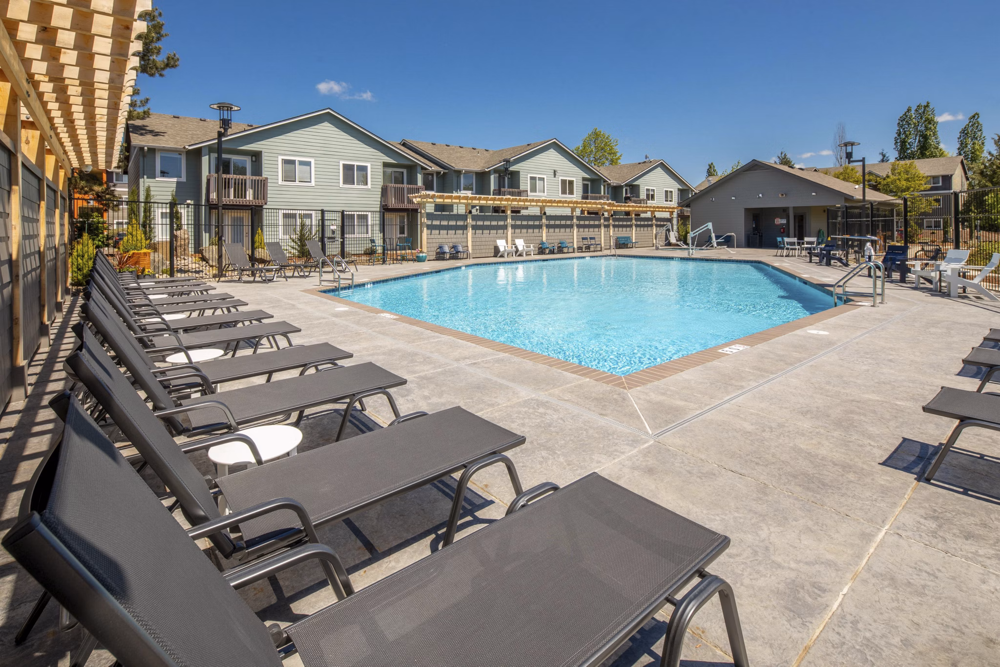 Luxury swimming pool at Creekside Apartments with lush landscaping and modern design