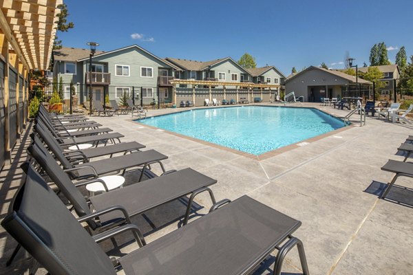 Luxury swimming pool at Creekside Apartments with lush landscaping and modern design