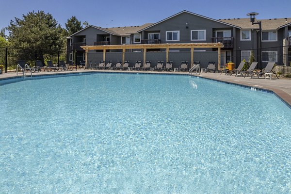 Creekside Apartments: Luxurious outdoor pool surrounded by lush landscaping