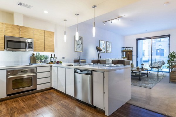 Modern kitchen featuring stainless steel appliances and granite countertops at Levare Apartments, luxury living by Greystar