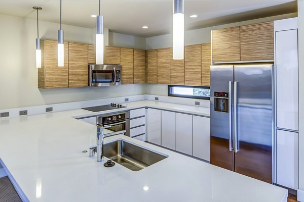 Modern kitchen with sleek countertops and stainless steel appliances at Levare Apartments