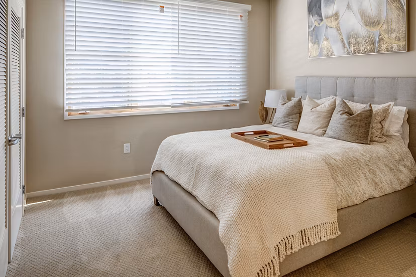 Spacious bedroom with modern decor at Santana Row Apartments in San Jose, featuring large windows and luxury finishes