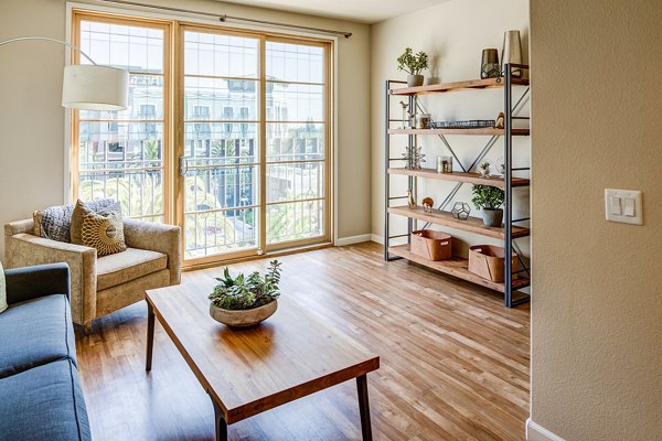 Spacious living room featuring modern decor and large windows at Santana Row Apartments in San Jose, offering luxurious living spaces
