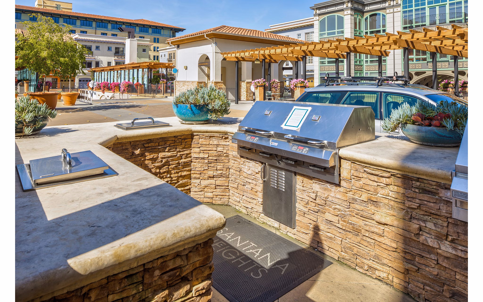 Grill area with dining tables at Santana Row Apartments: Ideal outdoor space for residents to socialize and enjoy cooking