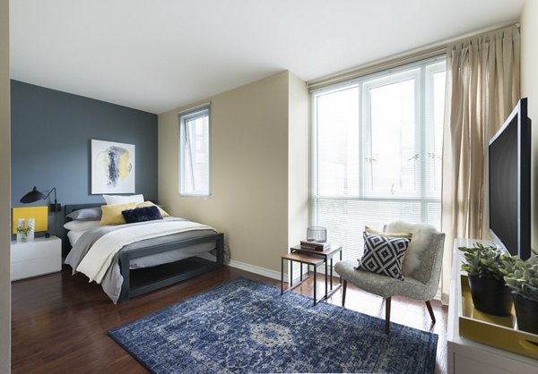 Cozy bedroom with elegant decor at Wilshire Vermont Station Apartments, featuring modern furnishings and ample natural light