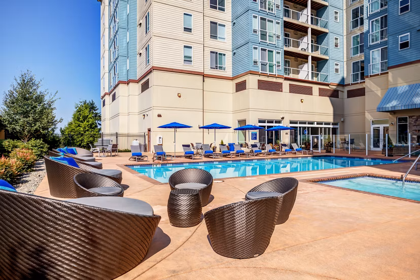 Modern outdoor pool with sun deck at Apex Apartments, offering luxury amenities in a vibrant community atmosphere