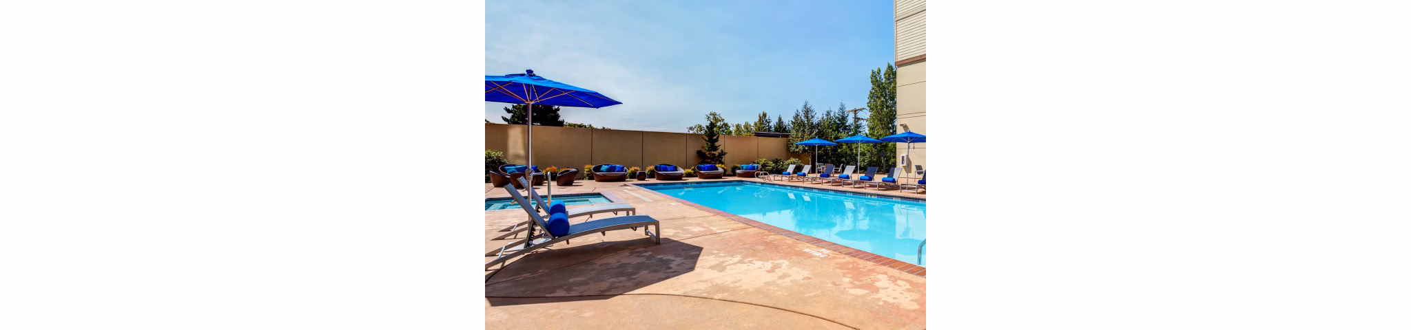 Luxurious pool with sun loungers at Apex Apartments, perfect for relaxation and leisure activities