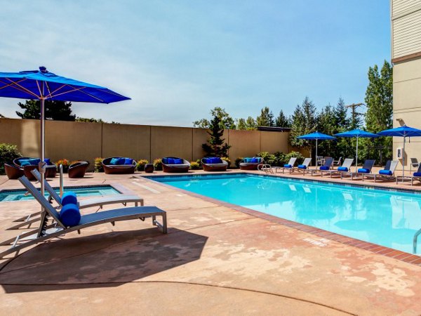 Luxurious pool with sun loungers at Apex Apartments, perfect for relaxation and leisure activities