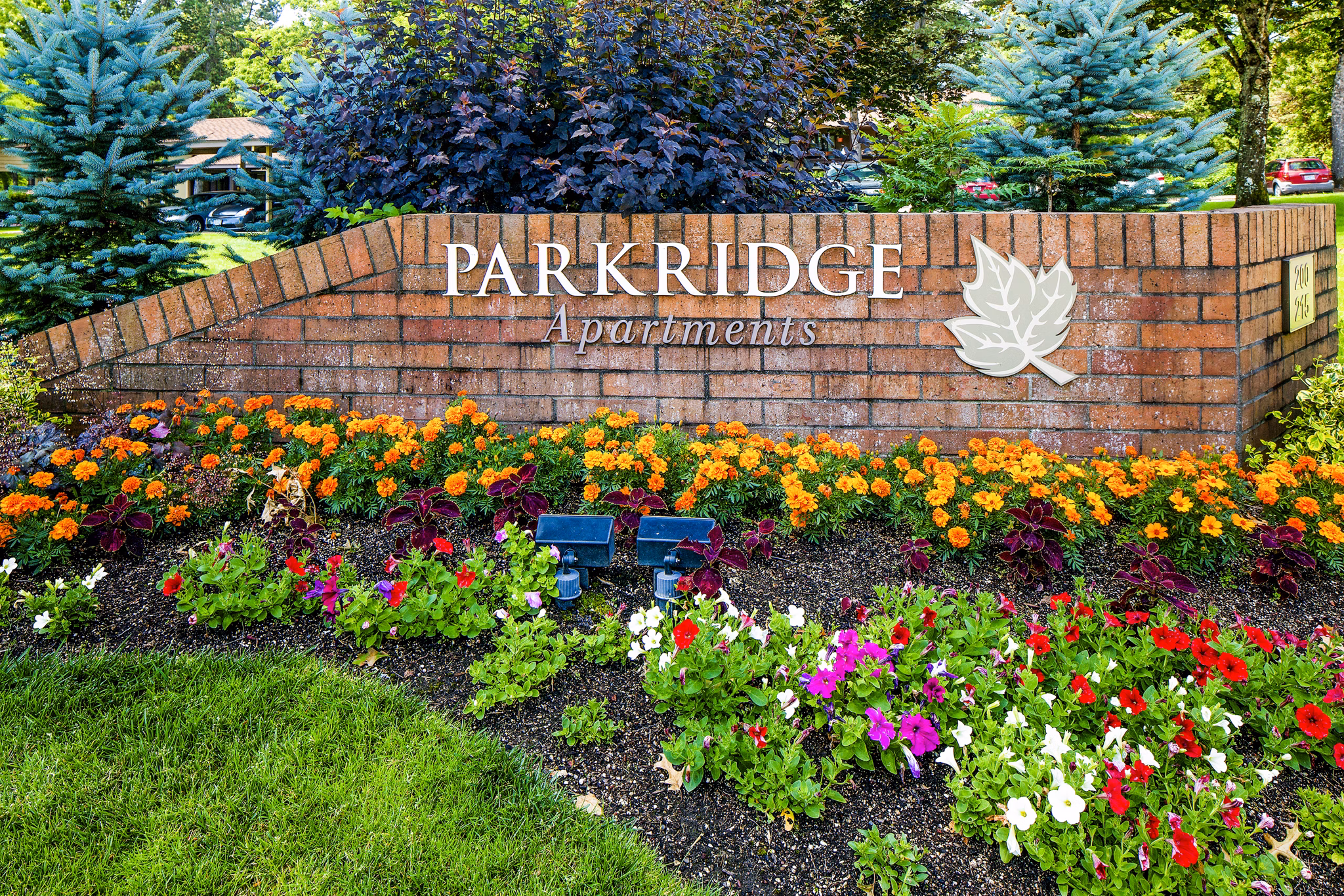 Parkridge Apartments sign with landscaped flowers and greenery in front of luxury apartment property