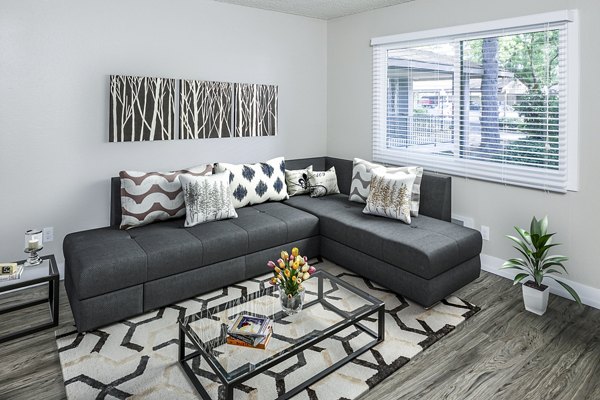 â€œSpacious living room with chic decor and ample natural light in Parkridge Apartments, luxury rentalsâ€
