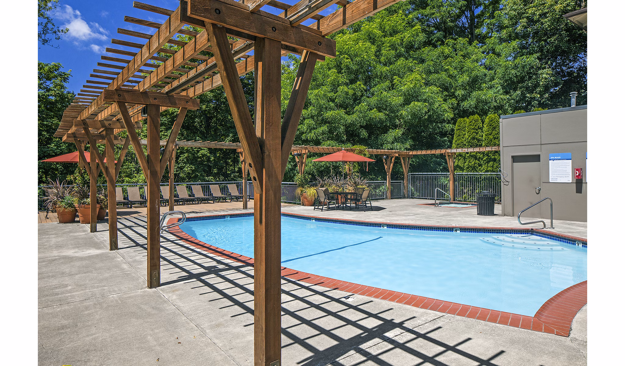 Inviting outdoor pool area at Parkridge Apartments with sun loungers and lush landscaping, offering a luxury retreat for residents
