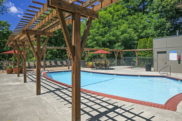Inviting outdoor pool area at Parkridge Apartments with sun loungers and lush landscaping, offering a luxury retreat for residents