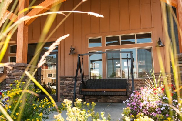 Sunny patio with modern furniture at The Homestead Apartments featuring scenic garden views