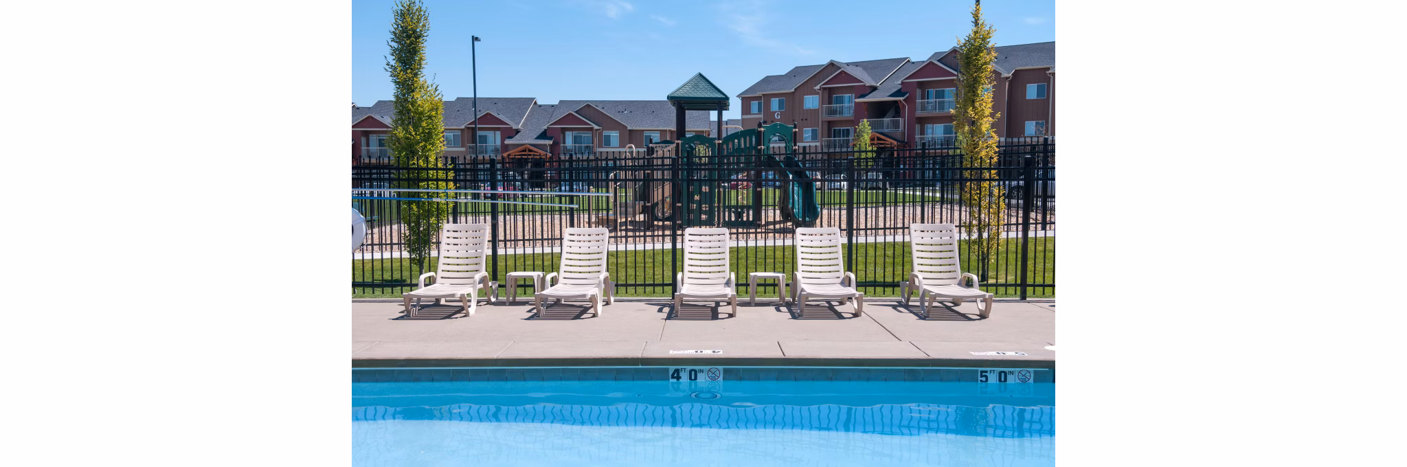 Outdoor pool with lush landscaping at The Homestead Apartments, a luxury living option by Greystar