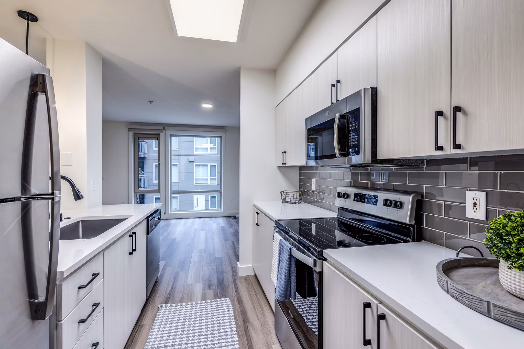 Modern kitchen with sleek countertops and stainless steel appliances at The Bristol at Southport Apartments, luxury residences