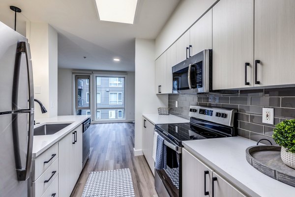 Modern kitchen with sleek countertops and stainless steel appliances at The Bristol at Southport Apartments, luxury residences