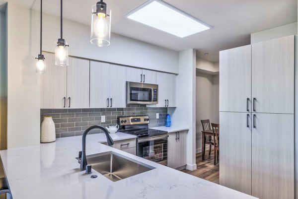 Modern kitchen with stainless steel appliances in The Bristol at Southport Apartments