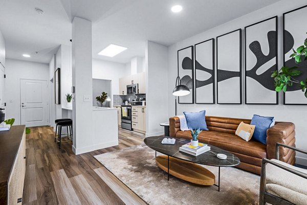 Cozy living room with contemporary decor and large windows in The Bristol at Southport Apartments