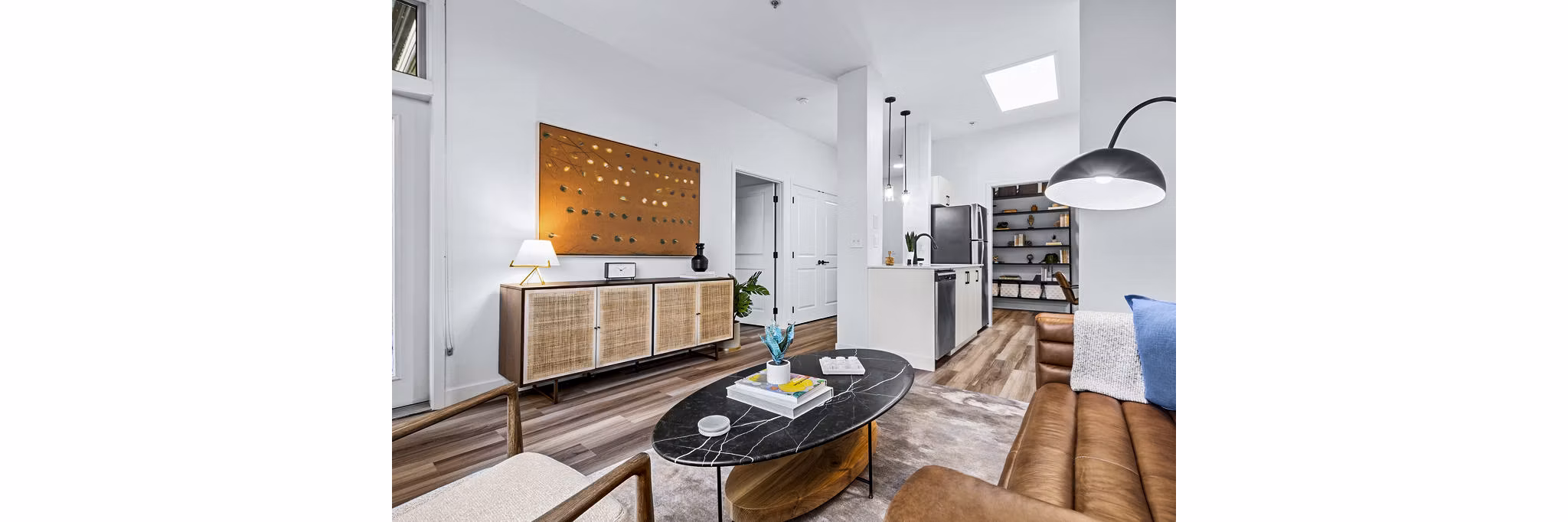 Chic living room with modern decor and large windows at The Bristol at Southport Apartments