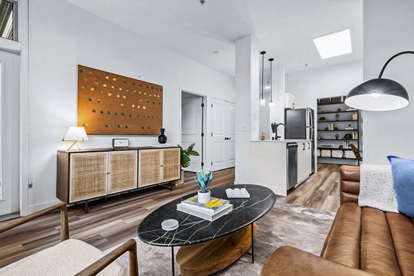 Chic living room with modern decor and large windows at The Bristol at Southport Apartments