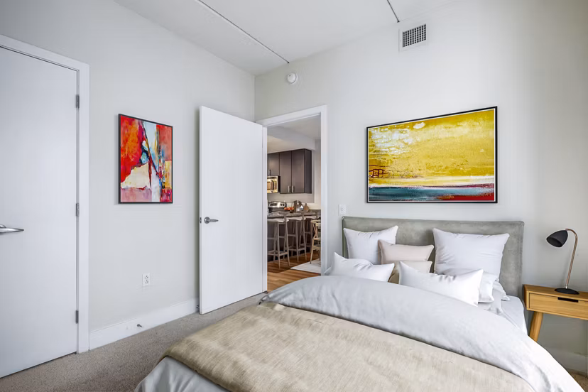 Elegant bedroom with large windows and modern decor at AQ Rittenhouse Apartments, luxury living in a prime location