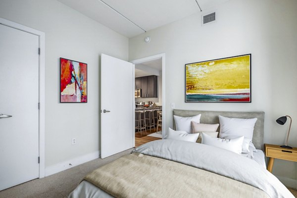 Elegant bedroom with large windows and modern decor at AQ Rittenhouse Apartments, luxury living in a prime location