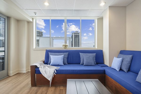Modern clubhouse with lounge seating and flat-screen TVs at AQ Rittenhouse Apartments, ideal for socializing and relaxation