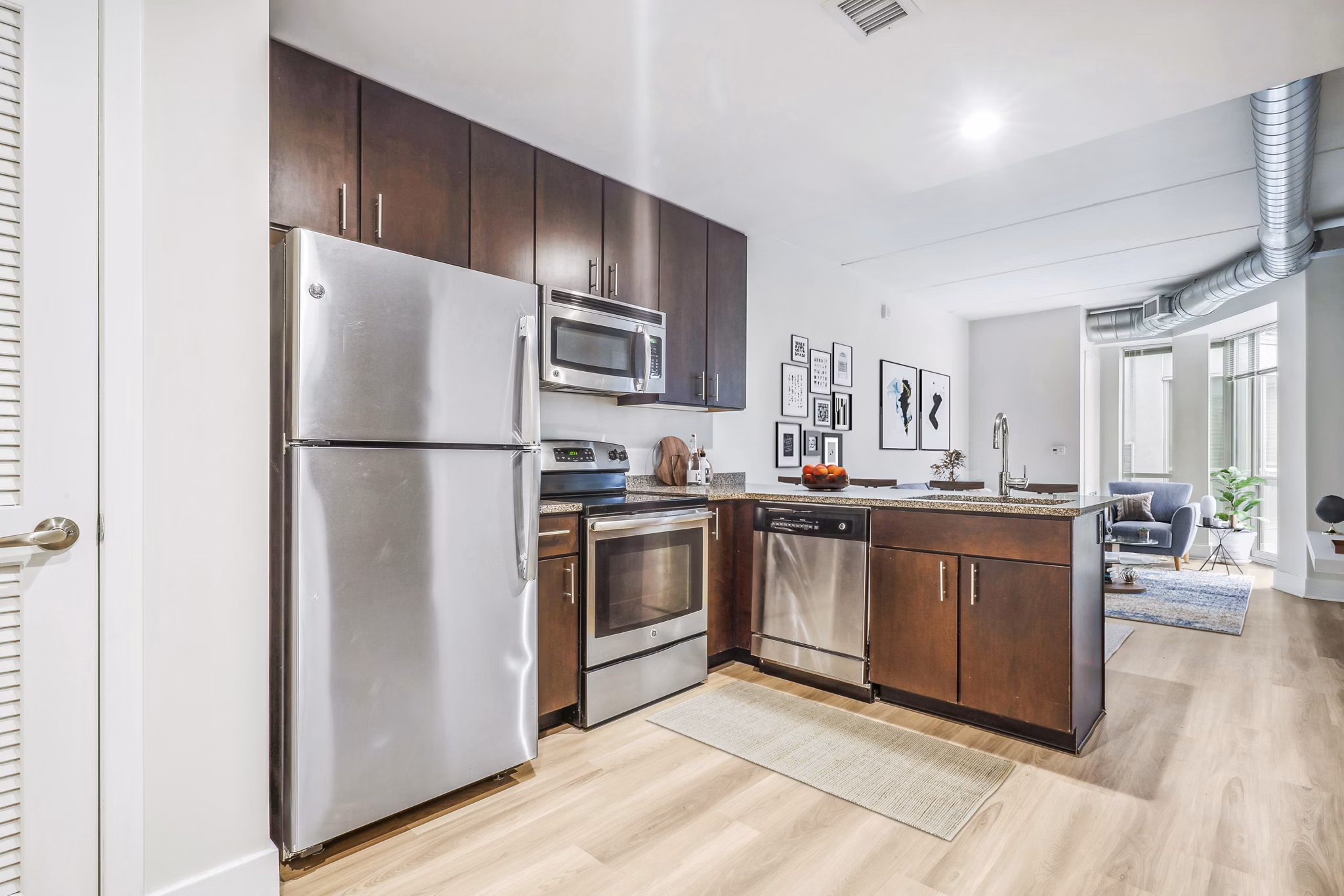 Modern kitchen featuring stainless steel appliances and granite countertops at AQ Rittenhouse Apartments