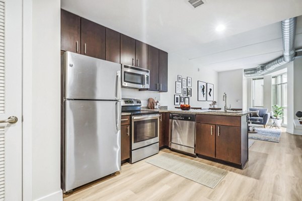 Modern kitchen featuring stainless steel appliances and granite countertops at AQ Rittenhouse Apartments
