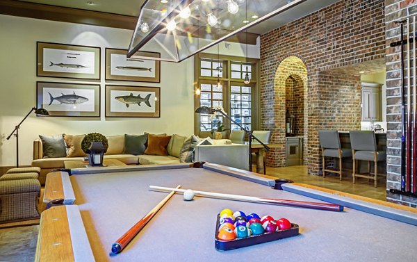 Stylish clubhouse with seating and billiards at Retreat at the Woodlands Apartments in a Greystar luxury community