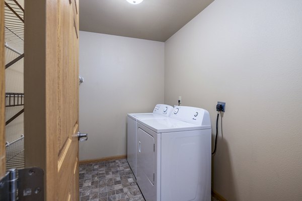 Laundry room with modern appliances at Plantation at Hunters Run Apartments
