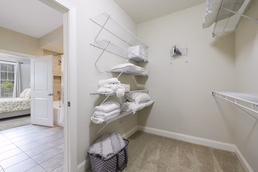 Walk-in closet featuring built-in shelves at Parkside Place Apartments