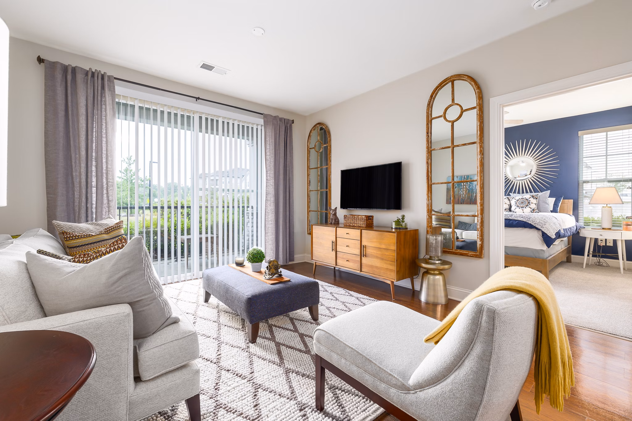 Spacious living room with chic decor and large windows at Parkside Place Apartments