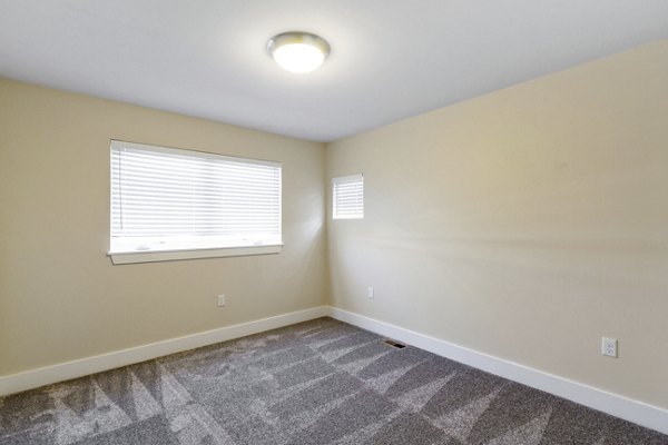 Bedroom with elegant decor and large window in Creekstone Twin Homes