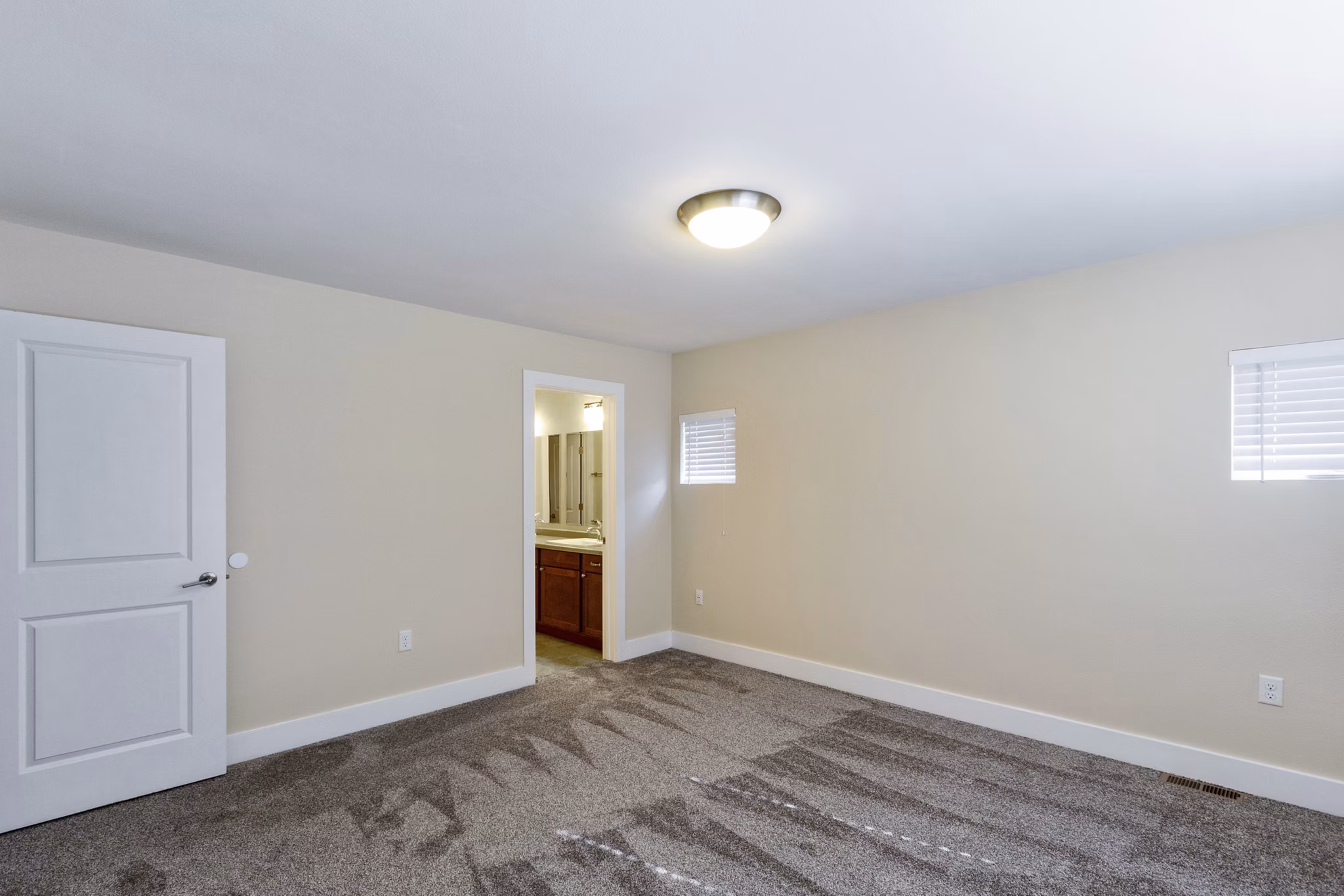 Bedroom with cozy dÃ©cor and large windows at Creekstone Twin Homes luxury apartments
